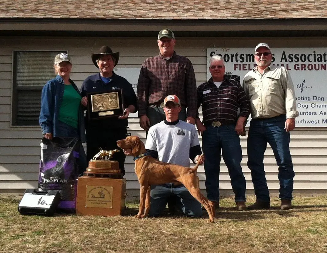 six people with a brown dog